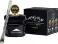 Srebrna szpatułka z napisem "Himalayan Shilajit" obok czarnego słoiczka i pudełka z górami. Certyfikaty potwierdzają jakość shilajitu.