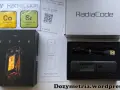 Zestaw Radiacode z dozymetrem ZERO, instrukcją i kablem USB. Obok pudełka z urządzeniem znajduje się karta z informacjami o izotopach Co-60 i Sr-90.