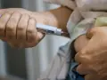 Dłoń trzymająca wstrzykiwacz z igłą, gotowa do podania leku. Może to być insulina lub inne leki, np. zawierające wanad.