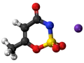Model cząsteczki acesulfamu K, słodzika o intensywnym smaku, z atomami węgla, tlenu, azotu, siarki i potasu.