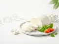 Czy mozzarella jest zdrowa? Świeża mozzarella z pomidorkami i bazylią na talerzu, symbolizująca zdrowy posiłek.