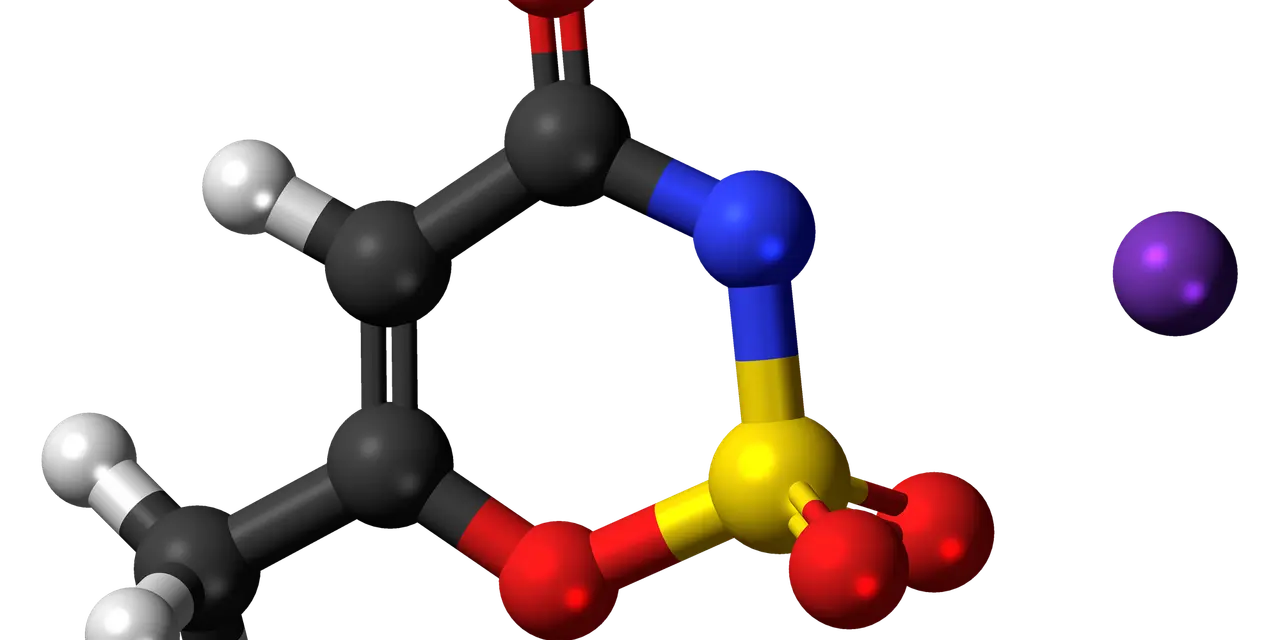 Model cząsteczki acesulfamu K, słodzika o intensywnym smaku, z atomami węgla, tlenu, azotu, siarki i potasu.