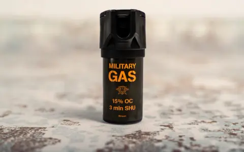 Czarny gaz pieprzowy z pomarańczowym napisem "MILITARY GAS" i informacją "Stream".