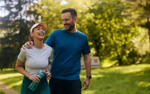 Szczęśliwa para spaceruje po parku. Czy koenzym q10 rano czy wieczorem? Zależy od Twoich celów!