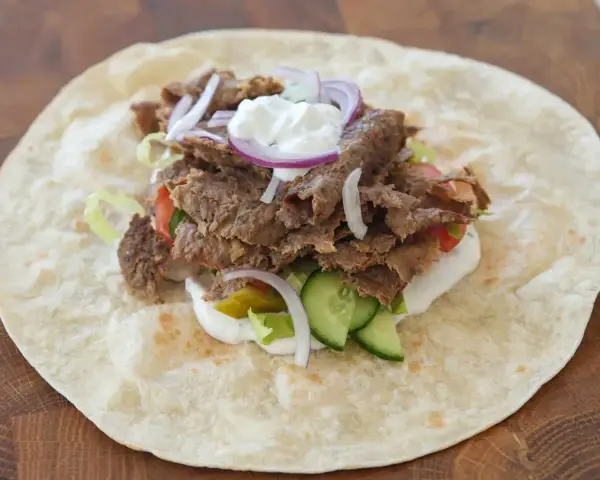 Pyszny kebab w tortilli z mięsem, warzywami i sosem. Zastanawiasz się, ile kcal ma kebab?