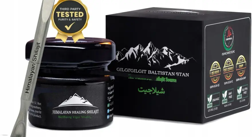 Srebrna szpatułka z napisem "Himalayan Shilajit" obok czarnego słoiczka i pudełka z górami. Certyfikaty potwierdzają jakość shilajitu.