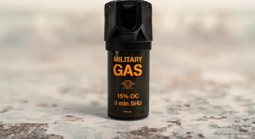 Czarny gaz pieprzowy z pomarańczowym napisem "MILITARY GAS" i informacją "Stream".