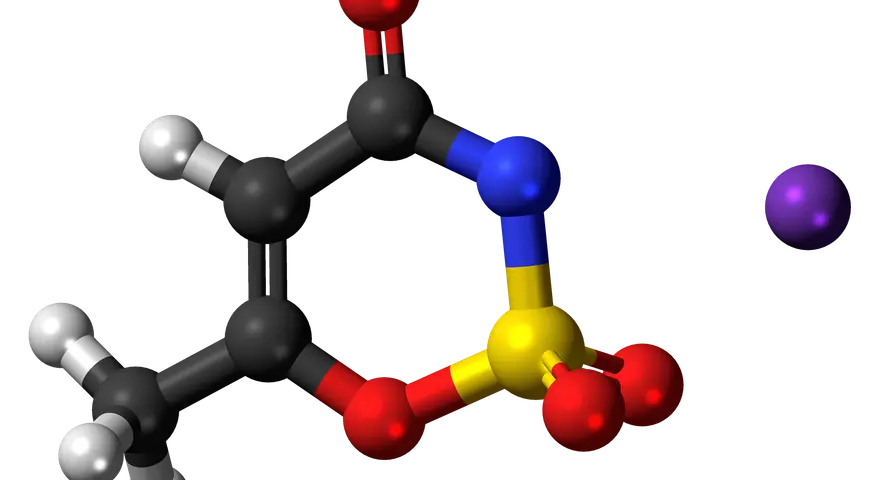 Model cząsteczki acesulfamu K, słodzika o intensywnym smaku, z atomami węgla, tlenu, azotu, siarki i potasu.